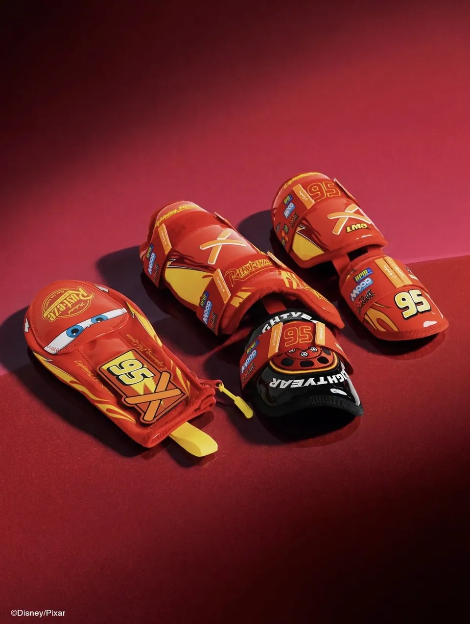 Absolutely Ridiculous × Cars baseball gear — Lightning McQueen sliding mitt, elbow and leg guards on red