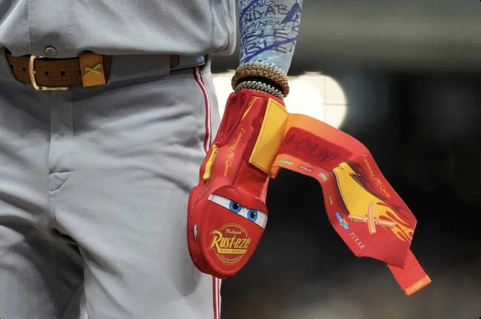 Cincinnati Reds player Elly De La Cruz on the field with the Lightning McQueen sliding mitt