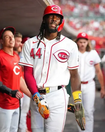 Elly De La Cruz in the Reds dugout with Woody sliding mitt and guards