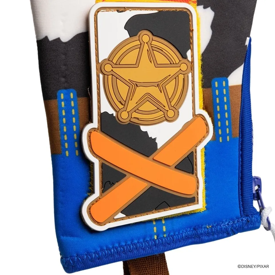 Sheriff badge and orange X patch over cowhide print on the Woody sliding mitt