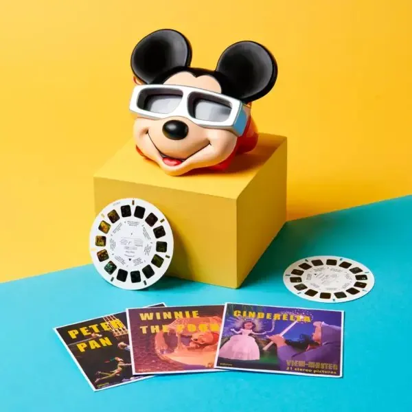 Mickey View-Master viewer on a yellow block with reels and retro reel packets for Peter Pan, Winnie the Pooh and Cinderella